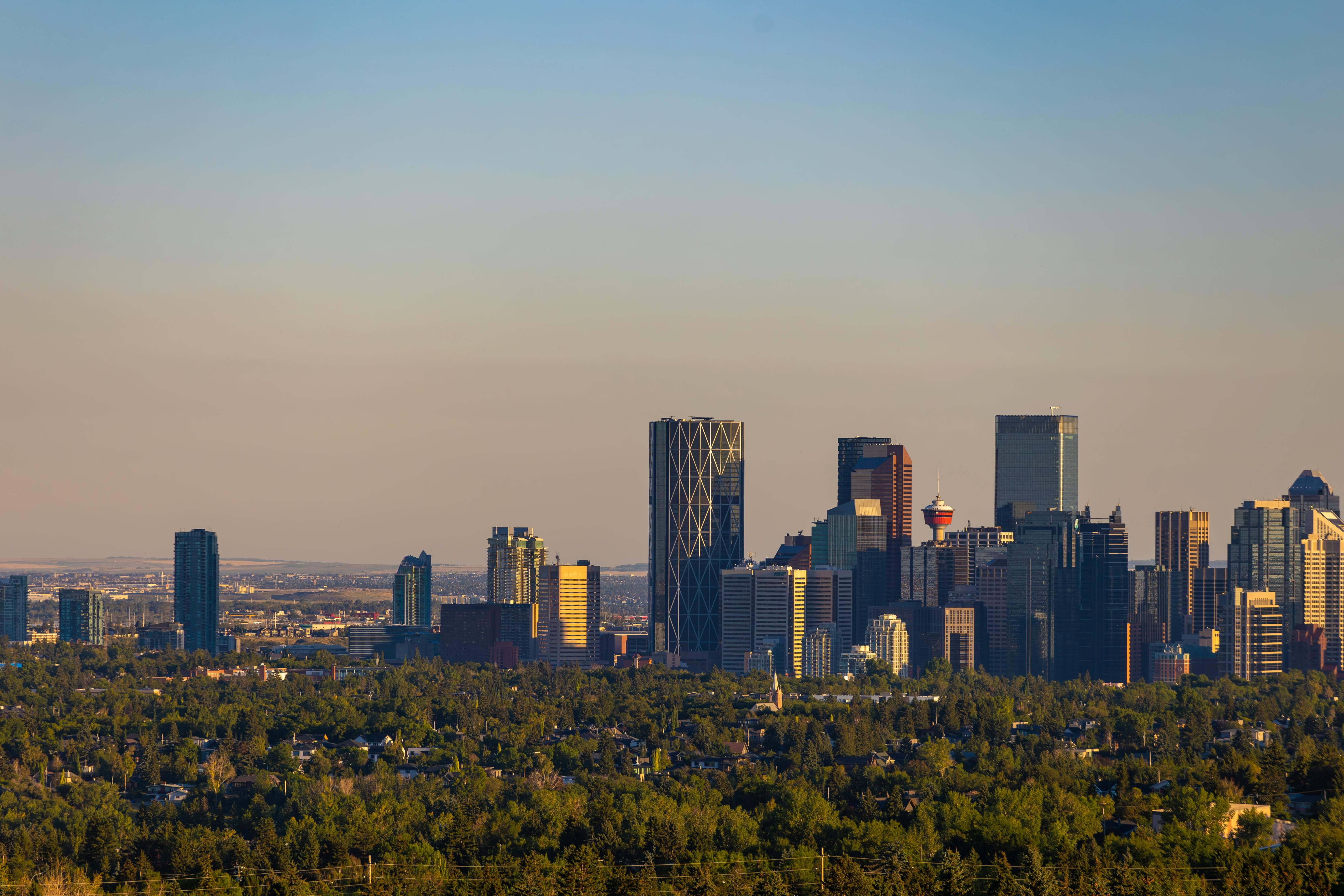 Downtown Calgary skyline at sunrise with the Calgary Tower and skyscrapers under a clear sky